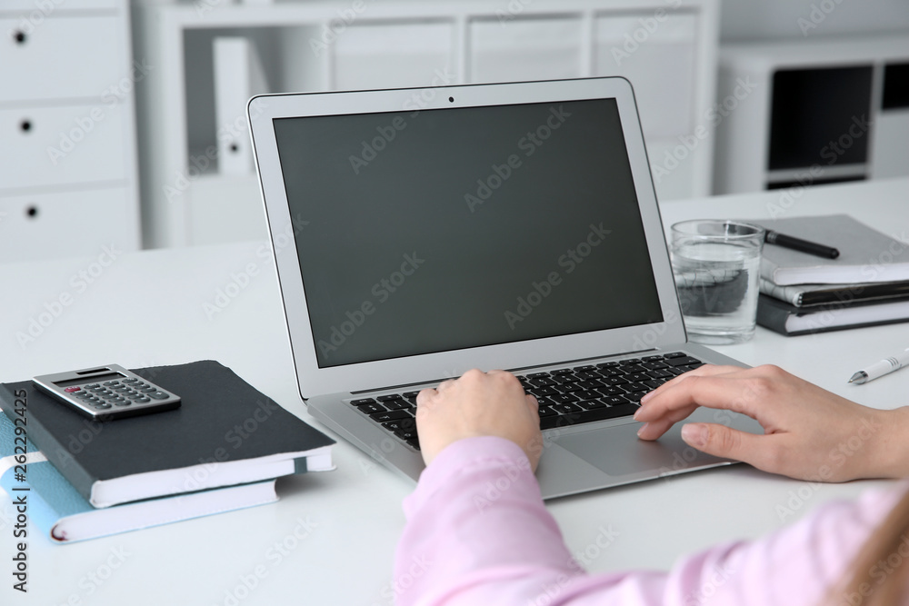 Young woman using modern laptop at table, closeup Young woman using modern laptop at table, closeup