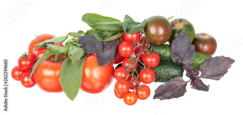 Fresh different red tomatoes, green cucumbers, purple and green basil and sage leaves isolated on white background. Ingredients for vegetable salad © kazakovmaksim