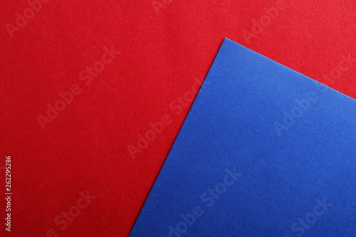 Blue and red paper sheets as colorful background, top view