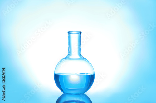 Laboratory flask with liquid on color background. Solution chemistry
