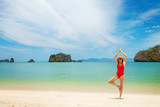 Young woman practice yoga on a beach