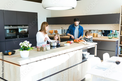 Obraz na plátně Beautiful cute family having fun while cooking together in the kitchen at home