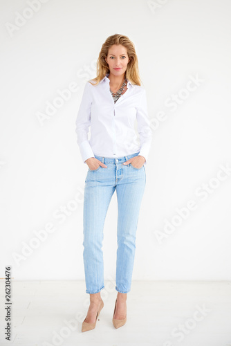 Full length shot of attractive middle aged woman wearing casual clothes while standing at isolated background