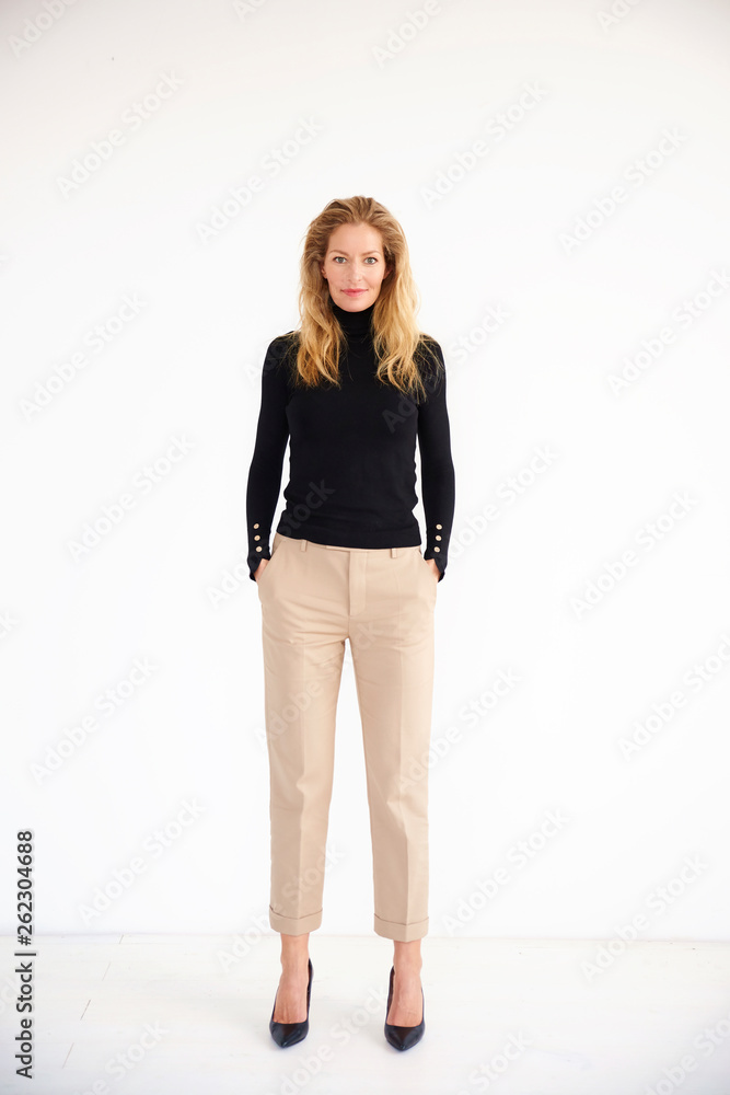 Full length shot of attractive middle aged woman wearing casual clothes while standing at isolated background Full length shot of attractive middle aged woman wearing casual clothes while standing at isolated background
