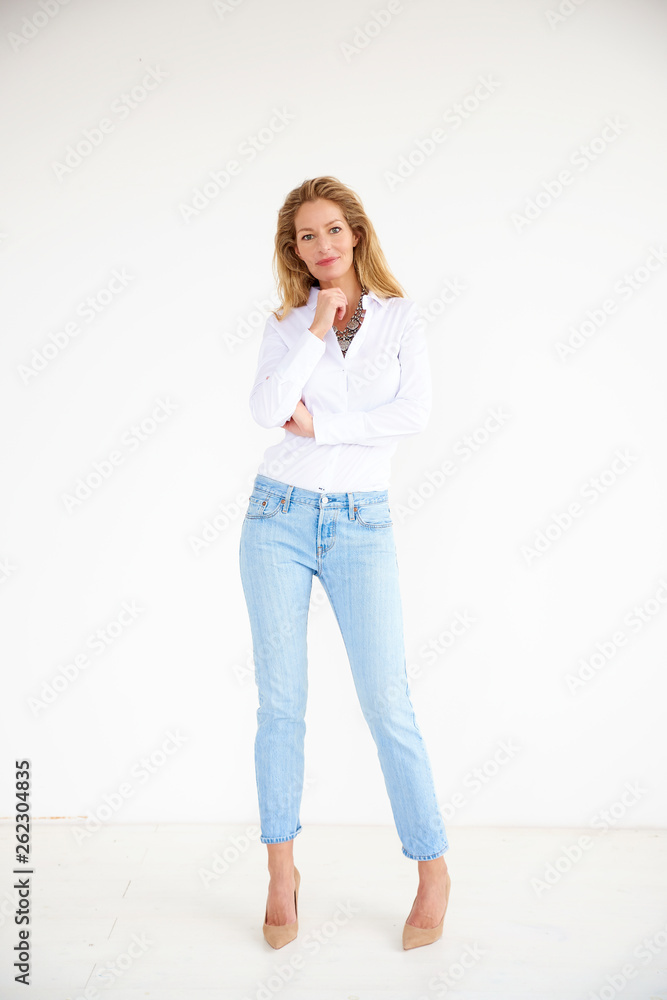 Full length shot of attractive middle aged woman wearing casual clothes while standing at isolated background Full length shot of attractive middle aged woman wearing casual clothes while standing at isolated background