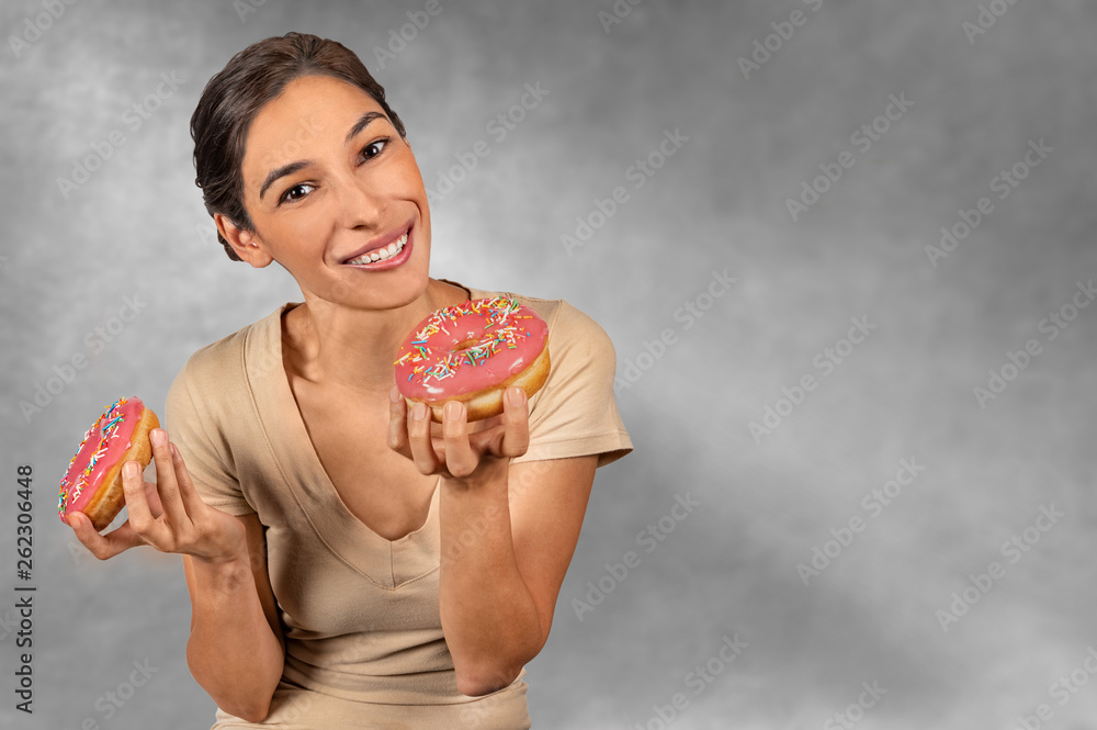Woman showing a pink donut, Happy to eat a reward after her hard diet Woman showing a pink donut, Happy to eat a reward after her hard diet