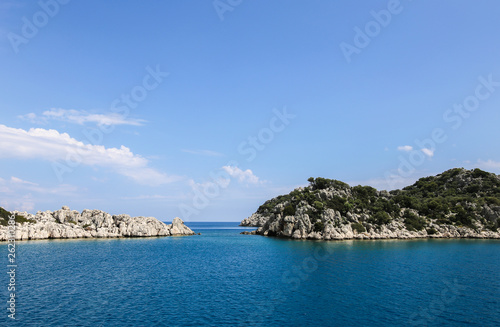 a view of the yacht on the blue waters and the various mountain scenery on the blue sky; travel pleasure in summer