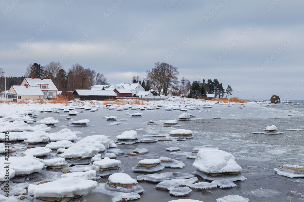 Ice-covered rocks on the shore of the Baltic Sea. Kasmu village, Estonia, winter daytime.
