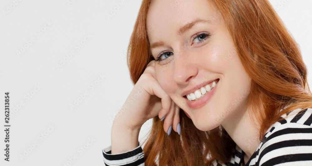 Red haired girl with close up macro face and perfect white teeth smile isolated on white background. Woman beauty and skin care. No make up concept. Redhead beautiful female. Selective focus. Banner Red haired girl with close up macro face and perfect white teeth smile isolated on white background. Woman beauty and skin care. No make up concept. Redhead beautiful female. Selective focus. Banner