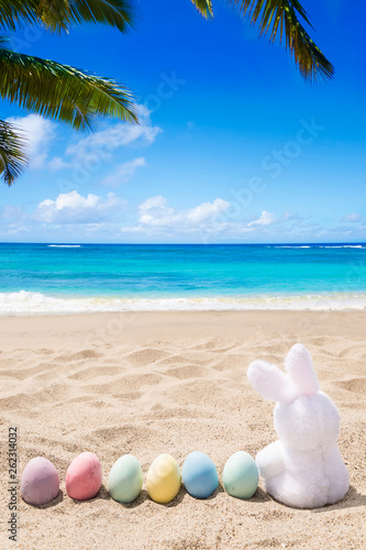 Beach Easter background with bunny and color eggs