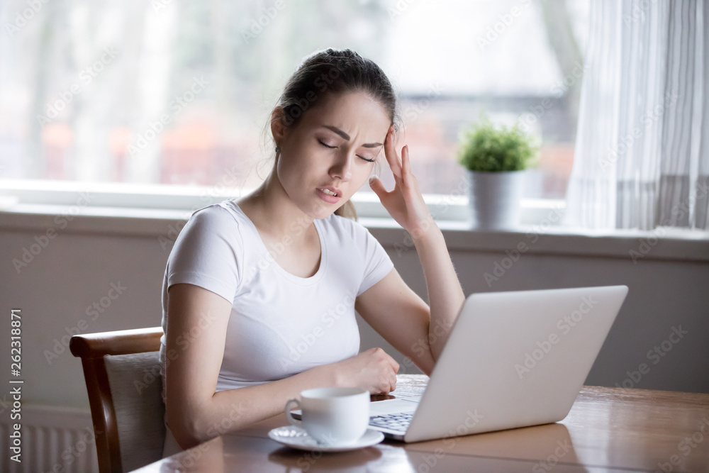 Young beautiful woman having headache working on computer at home Young beautiful woman having headache working on computer at home