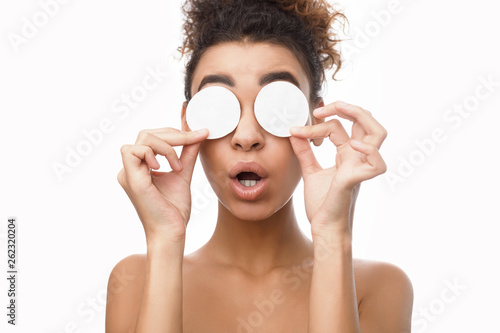 African woman with cotton pads on white background © Prostock-studio