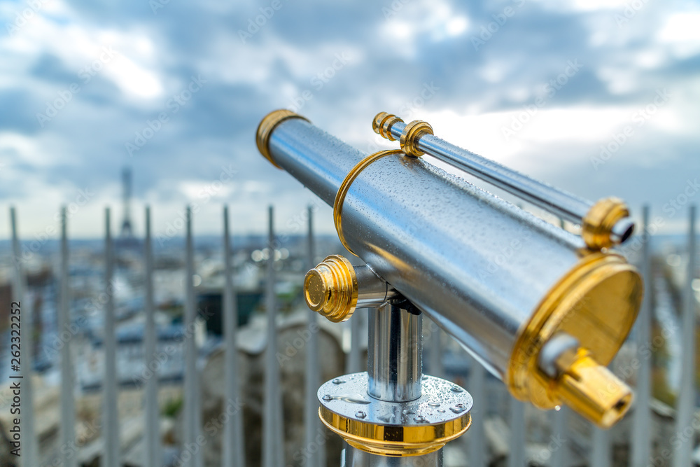 Touristic telescope or spyglass in rain drops directed towards the Eiffel Tower. Paris. France.