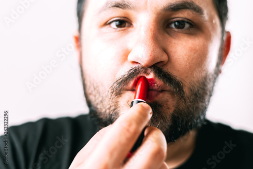 a man paints his lips with lipstick