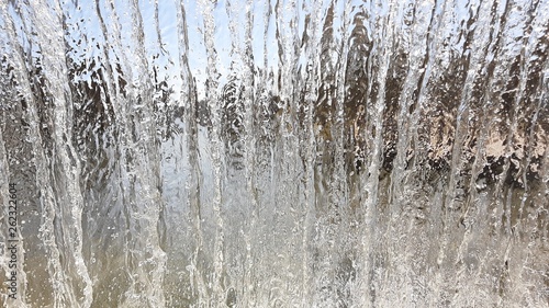 View from inside the waterfall. Streams of water flow from above. Shower and jet of fluid.