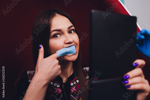 Portrait of young woman visiting dentist office for teeth whitening with photopolymer. photo