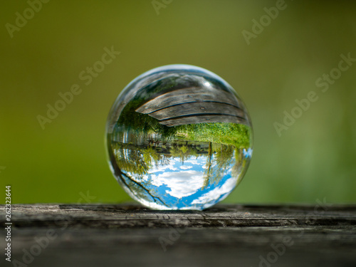 Εκτύπωση καμβά Landscape reflected in a crystal ball on an old wooden table