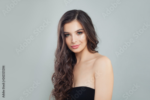 Glamorous brunette woman with makeup and long curly hair portrait