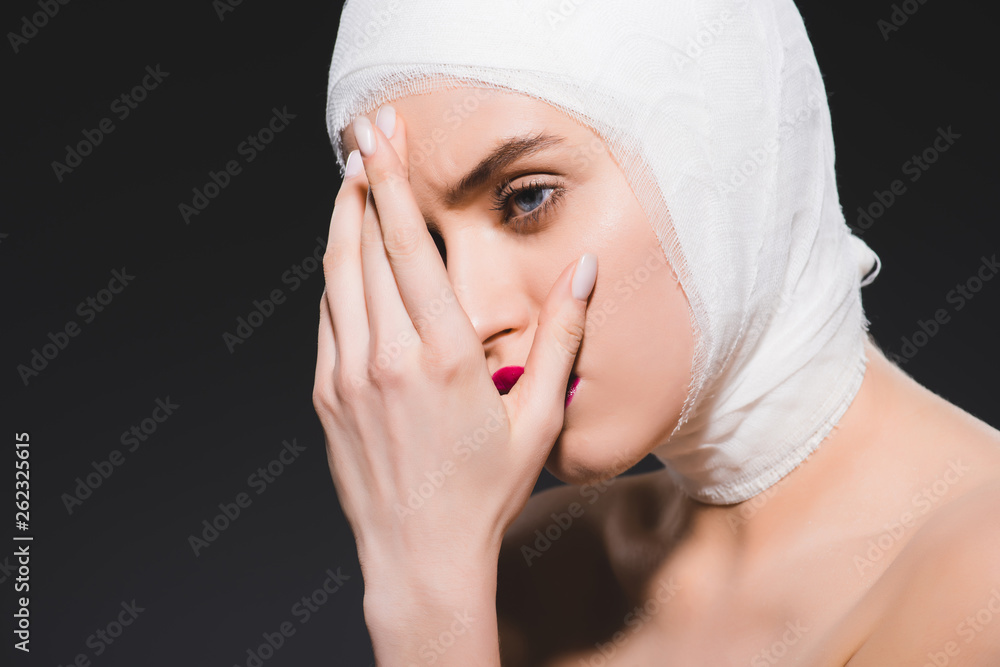 young woman with bandaged head covering face isolated on grey young woman with bandaged head covering face isolated on grey