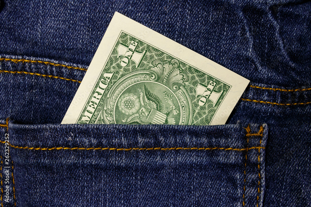 One dollar bill in a pocket of blue jeans One dollar bill in a pocket of blue jeans