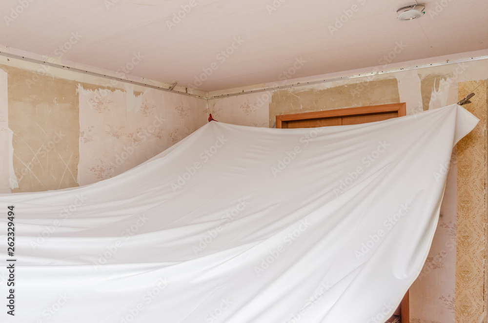 repairmen install stretch ceiling made of pvc vinyl film using a gas heat gun repairmen install stretch ceiling made of pvc vinyl film using a gas heat gun