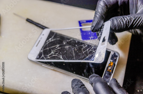 Technician or engineer opening broken smartphone for repair or replace new part on desk