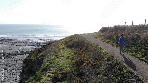 man hiking up the side of cliff face at the beach beautiful day 4k hiking on coastal path