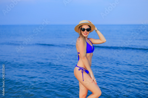 portrait of a beautiful girl in sunglasses, boater and blue swim © Ivan