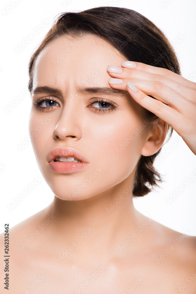 sad young woman touching face and looking at camera isolated on white