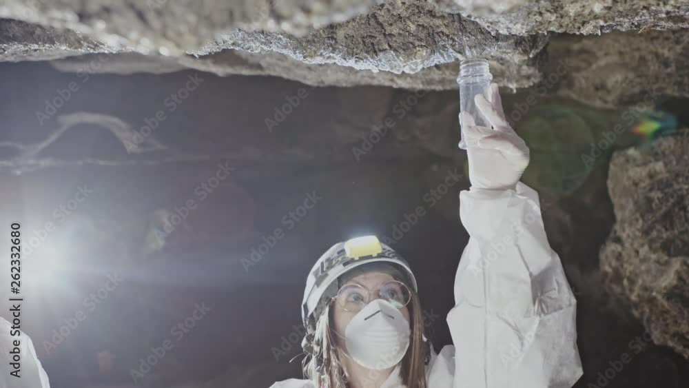 Biologists take a sample of water that cracks down from the cracks in ...