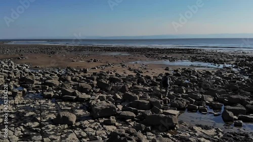 man walking across rocks on beach in slow motion 60fps stunning day 2.7k