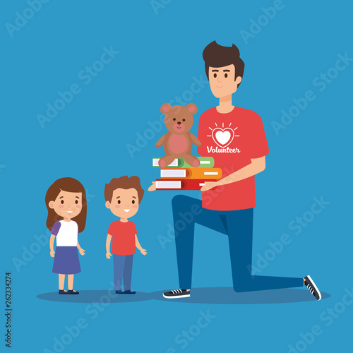 boy volunteer with books and teddy to kids