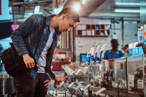Photography Young asian man is choosing products at market