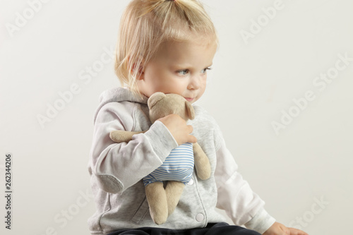 An adorable baby girl hugging with her favorite soft toy