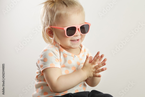 Studio shot of an adorable baby girl wearing sunglasses and clapping hands  the importance of exposing children to music concept