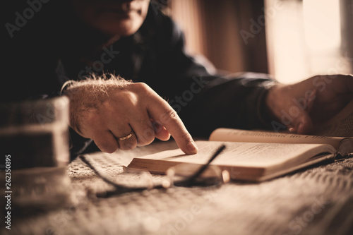Hand of senior man reading book in nursing home
