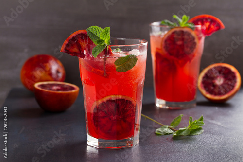 Blood orange cocktail with slices of citrus fruits and mint