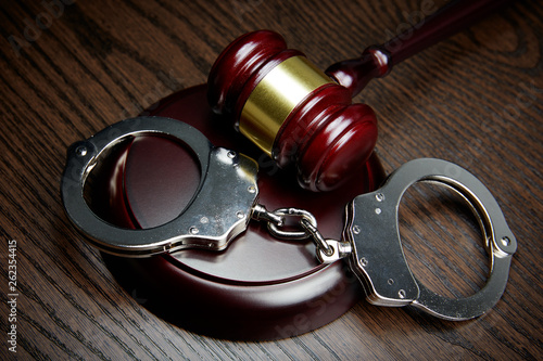 GAVEL AND HANDCUFFS ON WOOD
