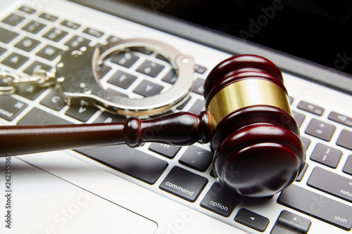 GAVEL, HANDCUFFS ON COMPUTER KEYBOARD