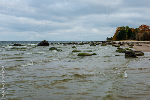 stormy sea beach with large rocks in the wet sand