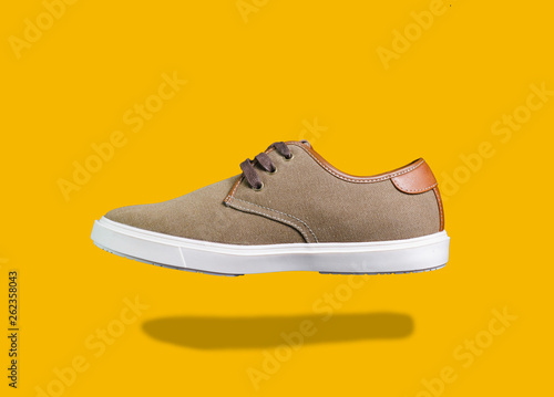 Canvas and leather sneakers isolated on color background