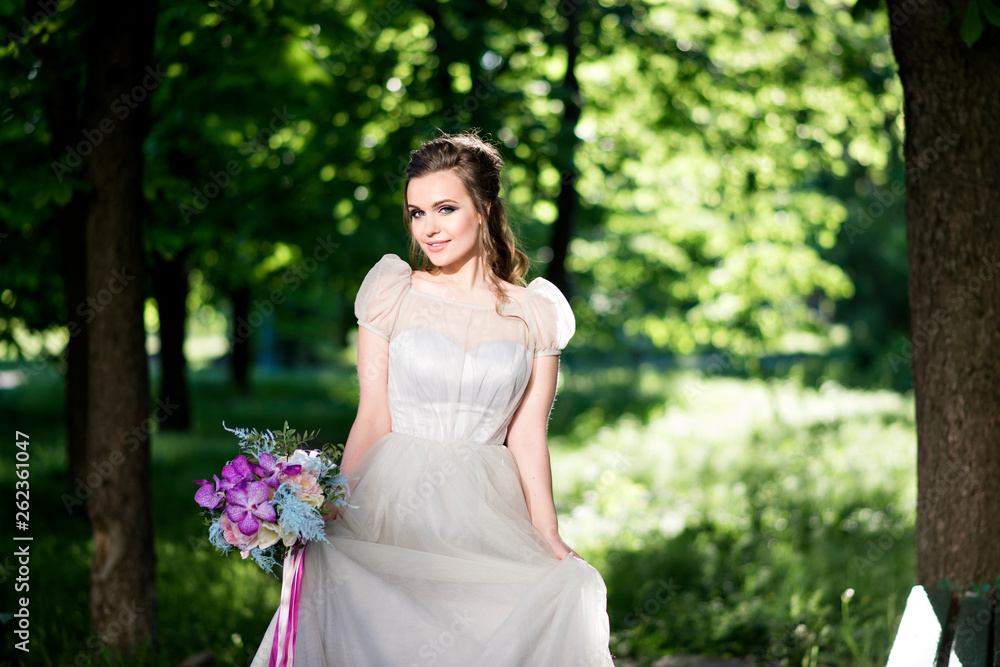 Incredible, beautiful, stylish modern bride. Wedding makeup, dress and bouquet. Walk the bride in the park. Wedding hairstyle Incredible, beautiful, stylish modern bride. Wedding makeup, dress and bouquet. Walk the bride in the park. Wedding hairstyle