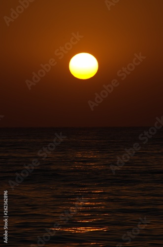 Fototapeta Naklejka Na Ścianę i Meble -  Sunset with large yellow sun under the sea surface