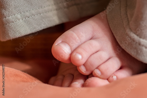 Happy child posing in room. Feet baby closeup. Little plump fingers.