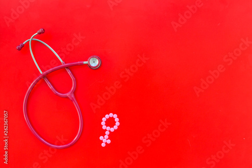 stethoscope and female symbol for diagnostic and cure of gynaecological disease on red background top view mockup