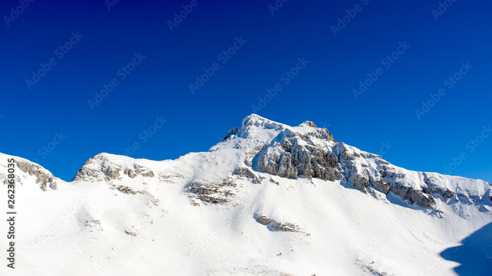 Winter landscape with the mountain peaks covered by heavy snow. Aerial view by drone. 