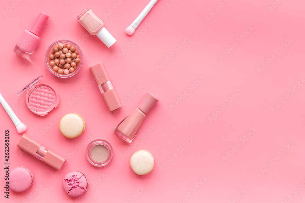 Make-up artist desk with powder, nail polish, decorative cosmetics and macaroon cookies pink background top view mokeup Make-up artist desk with powder, nail polish, decorative cosmetics and macaroon cookies pink background top view mokeup
