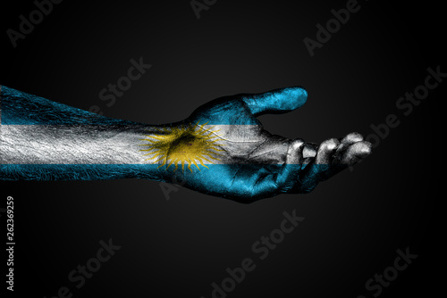 Outstretched hand with a drawn Argentina flag, a sign of help or a request, on a dark background