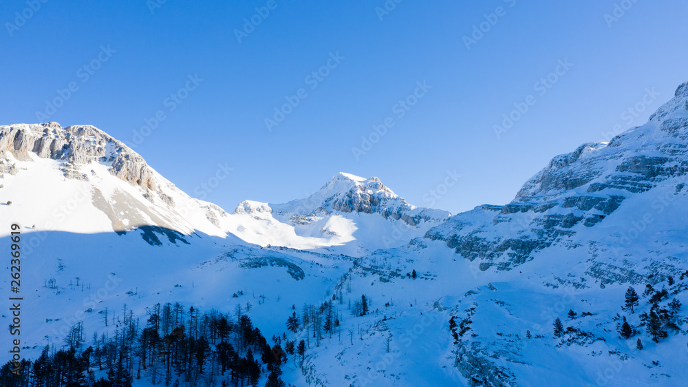 Winter landscape with the mountain peaks covered by heavy snow. Aerial view by drone. 