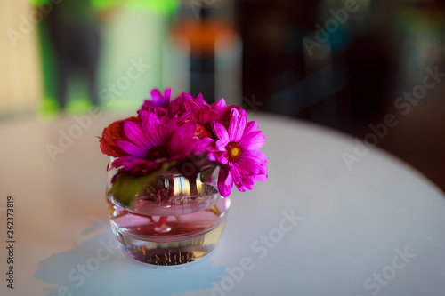 Lilac flowers in a small glass vase. Floral decoration of restaurant tables. Lush colors of spring in the interior decor.